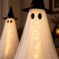 Close-up of the warm lights, white gauze and black witch hat.